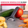 Éplucheur gris sur plan de travail à côté d'une pomme rouge partiellement épluchée, pelures de pomme, tranches de pomme et une courgette verte en arrière-plan