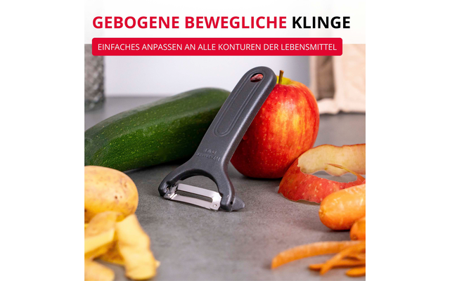 Éplucheur gris sur plan de travail à côté d'une pomme rouge partiellement épluchée, pelures de pomme, tranches de pomme et une courgette verte en arrière-plan