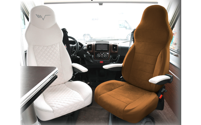 Two driver seats in a vehicle, one white and one brown seat, surrounded by armrests and a table