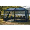 Donkerblauw gaaspaviljoen bij een meer, met een inklapbare tafel met flessen en vier campingstoelen; gras op de voorgrond, bomen op de achtergrond