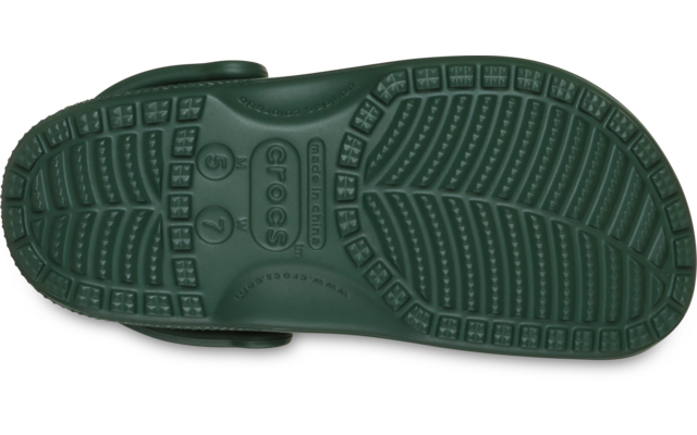 Grüne Sohle eines Clogs mit Profil, Aufschrift 'CROCS' und Fersenriemen