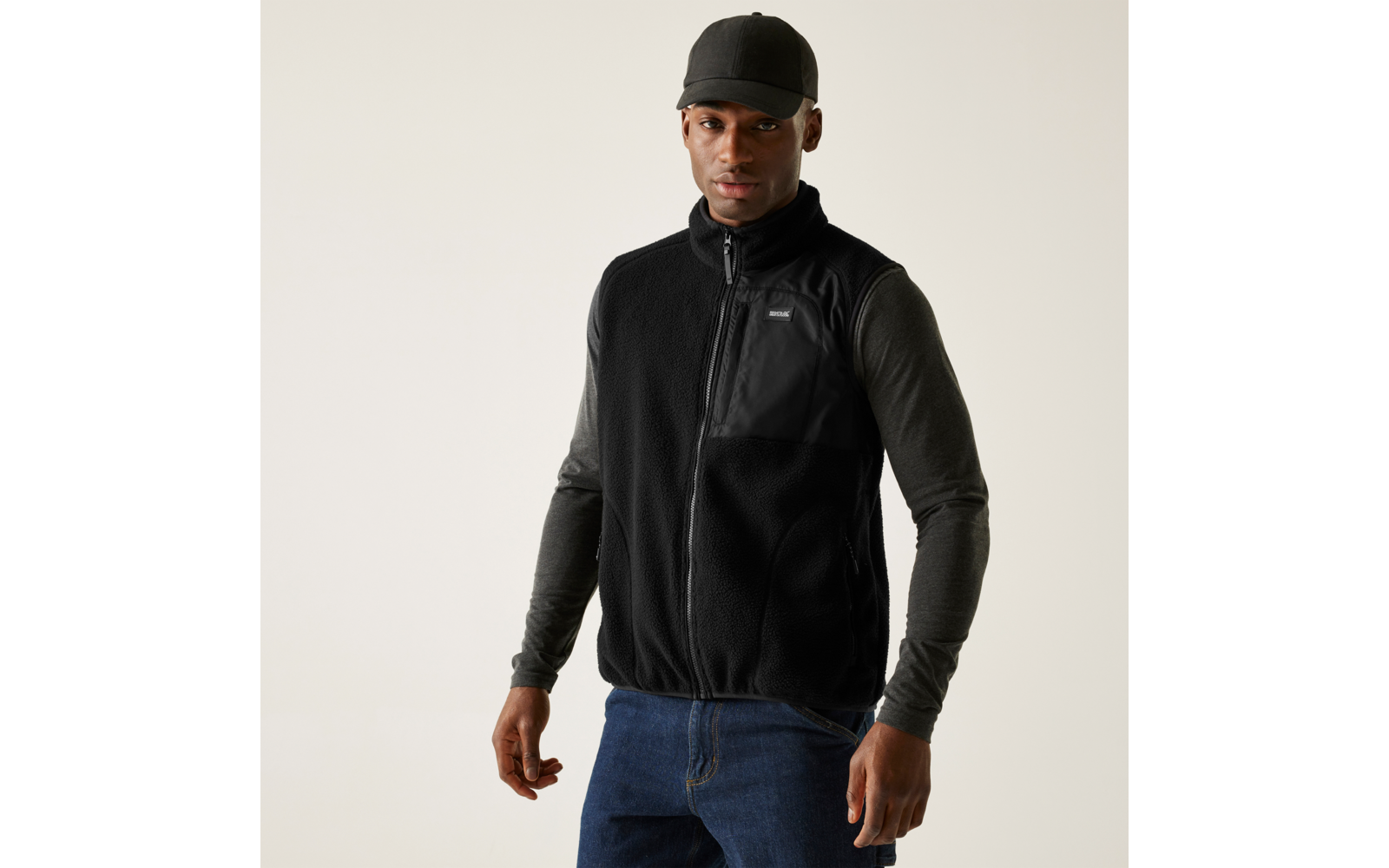 Mann trägt schwarze Weste und graues Langarmshirt mit schwarzer Mütze