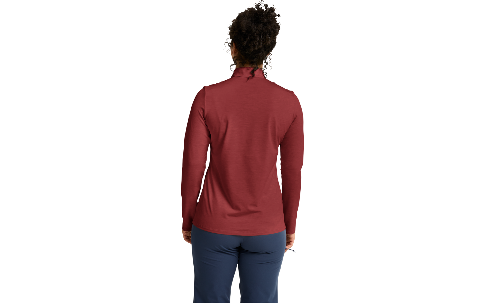 Persona vista de espaldas con prenda de manga larga roja y pantalones azules, cabello rizado oscuro recogido en un moño