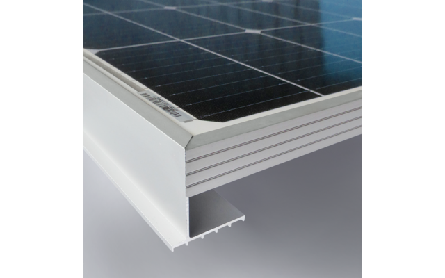 Close-up van een hoek van een zonnepaneel met zwarte zonnecellen en een zilverkleurig aluminium frame