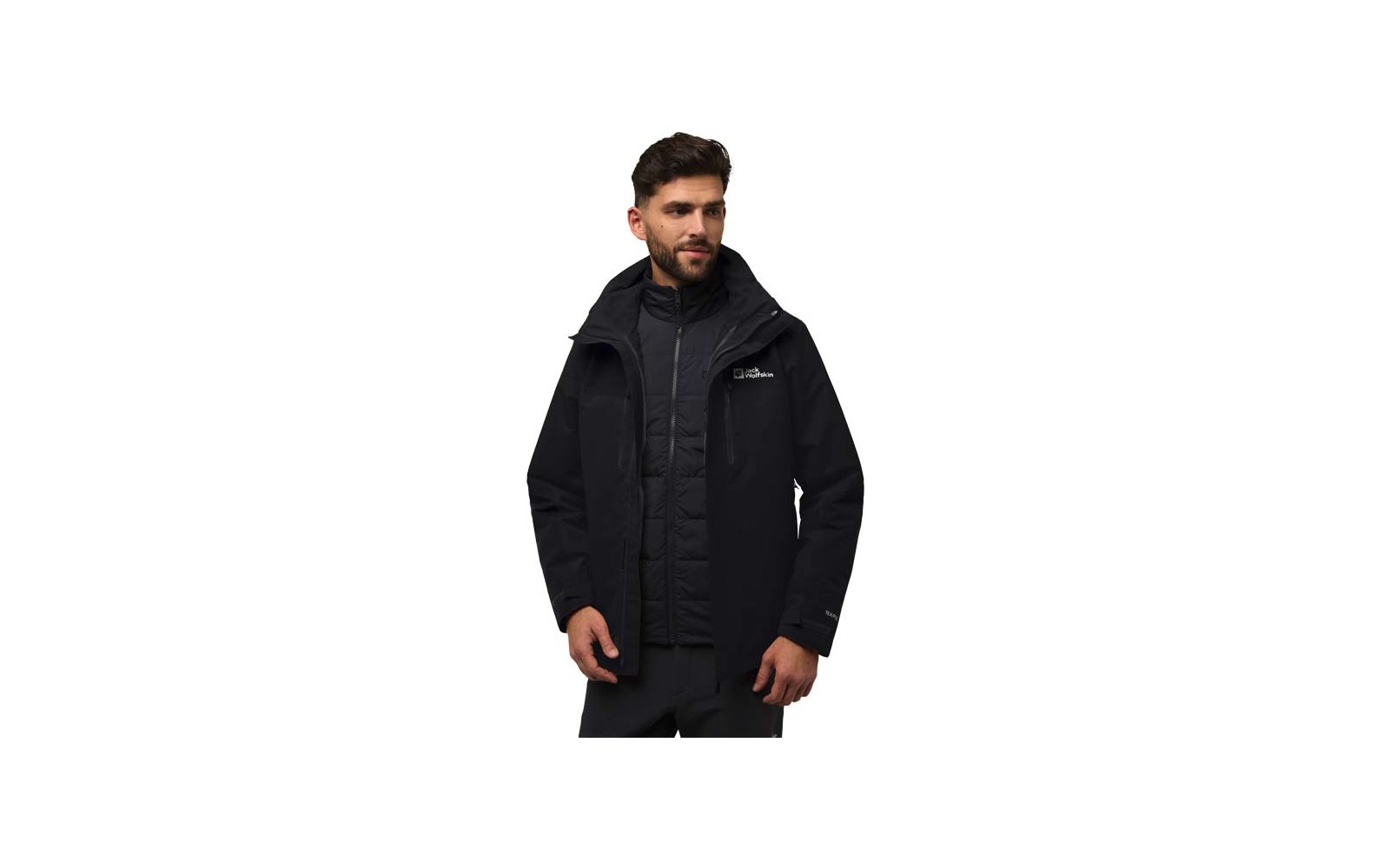 Homme aux cheveux courts foncés et barbe portant une veste à capuche noire par‑dessus une doudoune matelassée sur fond blanc