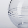 Gros plan d'une sphère transparente en plastique avec une ligne de joint et des fermoirs à clip sur fond clair
