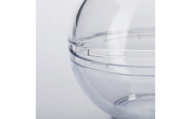 Gros plan d'une sphère transparente en plastique avec une ligne de joint et des fermoirs à clip sur fond clair