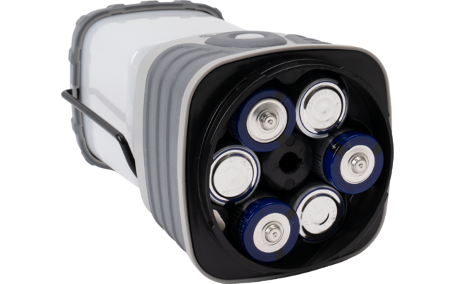 Wit-grijs cilindrisch verlichtingsapparaat met zwarte onderkant; zes zichtbare blauw-zilverkleurige cilindrische batterijen in het bodemvak; metalen handgreep aan de zijkant