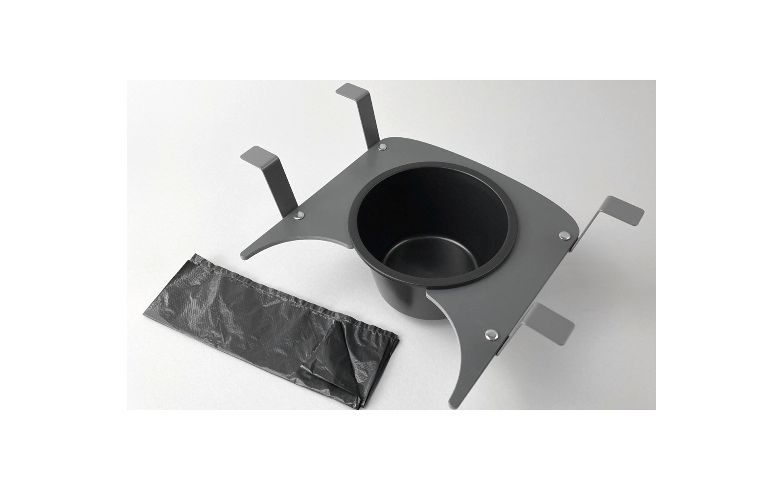 Porte-gobelet noir avec clips de fixation et une feuille en plastique noire à côté du porte-gobelet