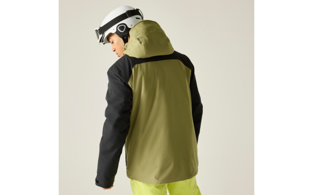 Person mit weißem Helm, olivgrüner Jacke mit schwarzen Ärmeln und gelben Hosen, teilweise von hinten vor neutralem Hintergrund
