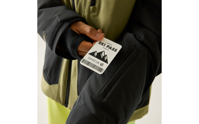 Hand hält eine Karte mit der Aufschrift "SKI PASS", Bergsymbol und Barcode vor einer schwarzen und olivgrünen Jacke