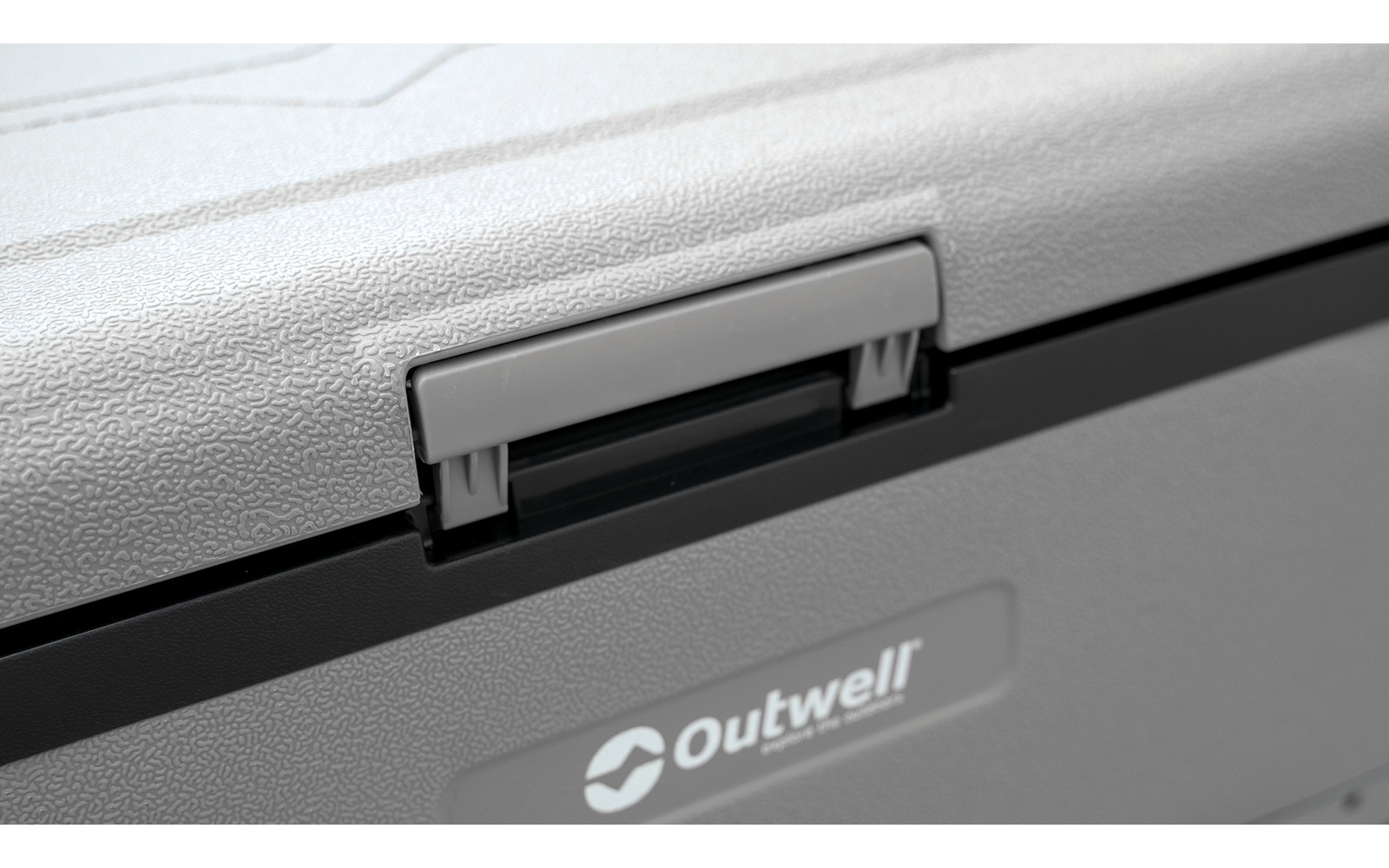 Gros plan d'un loquet en plastique gris sur le bord supérieur d'un contenant gris avec le logo "Outwell" visible