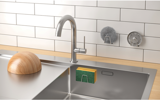 Küchenarbeitsplatte mit Edelstahlspüle, Wasserhahn und Holzschneidebrett vor weiß gefliester Wand
