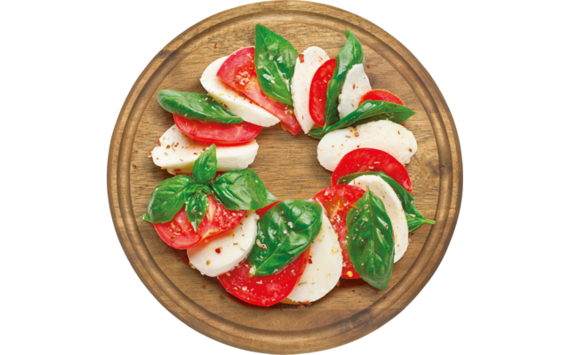 Ein Teller mit Mozzarella, Tomatenscheiben und frischem Basilikum