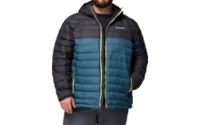 Mann trägt eine gesteppte Jacke in Dunkelblau und Schwarz mit grüner Reißverschlussleiste