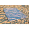 Sac de couchage bleu clair posé à plat sur le sable
