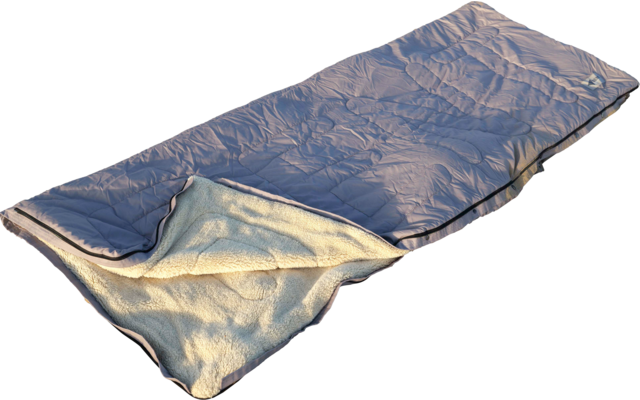 Sac de couchage bleu ouvert avec doublure claire en polaire posé sur du sable avec empreintes de pas