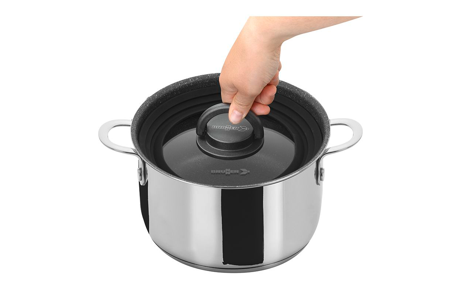 Main saisissant le bouton d'un couvercle en verre sur une casserole en acier inoxydable avec deux poignées