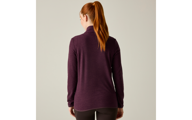 Vista posteriore di una persona con una coda di cavallo rossa che indossa una maglia viola a maniche lunghe e pantaloni scuri su sfondo chiaro