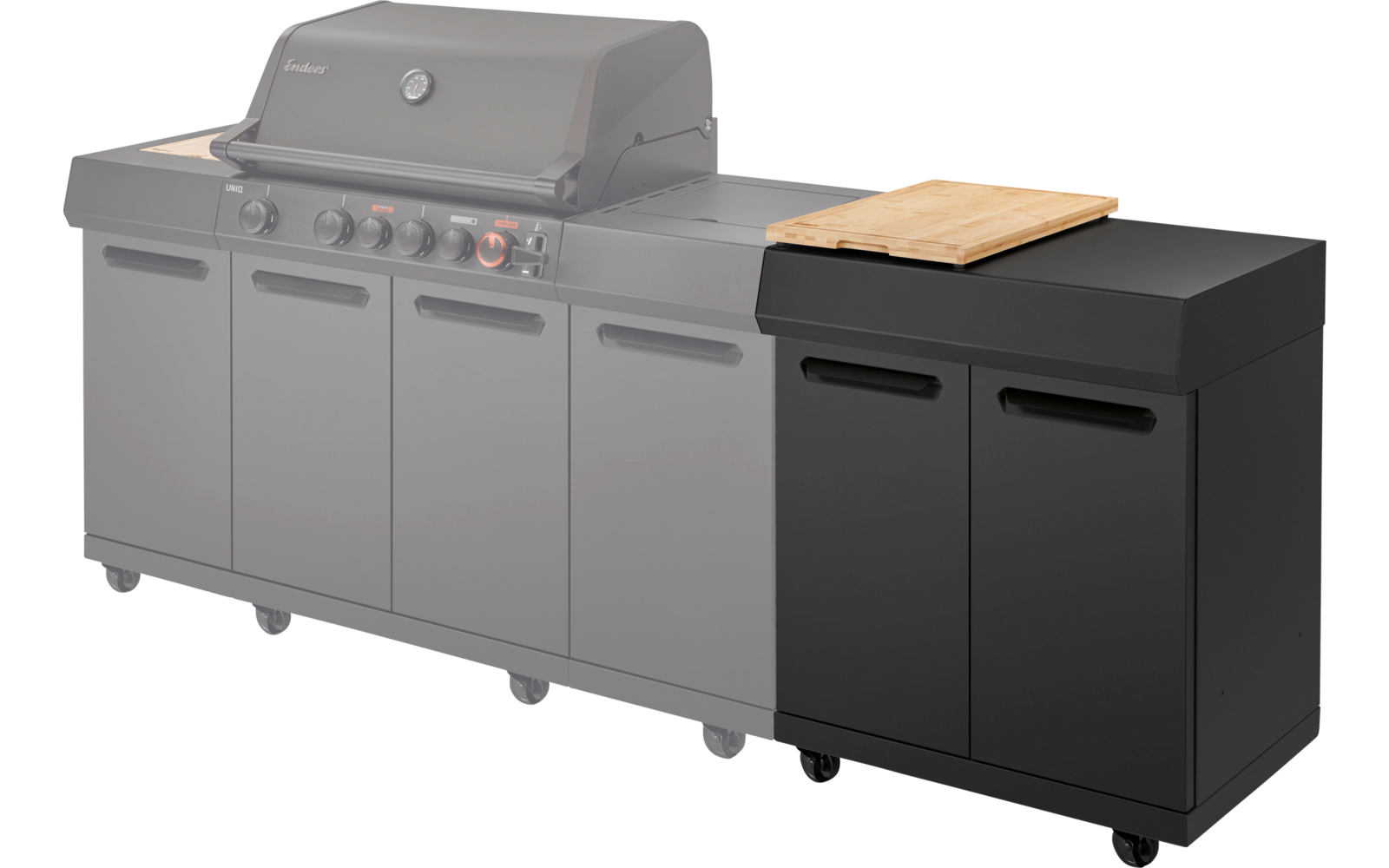 Large grill with closed hood and four control knobs, three cabinet doors below; to the right a black rolling cabinet with two doors and a wooden cutting board on top