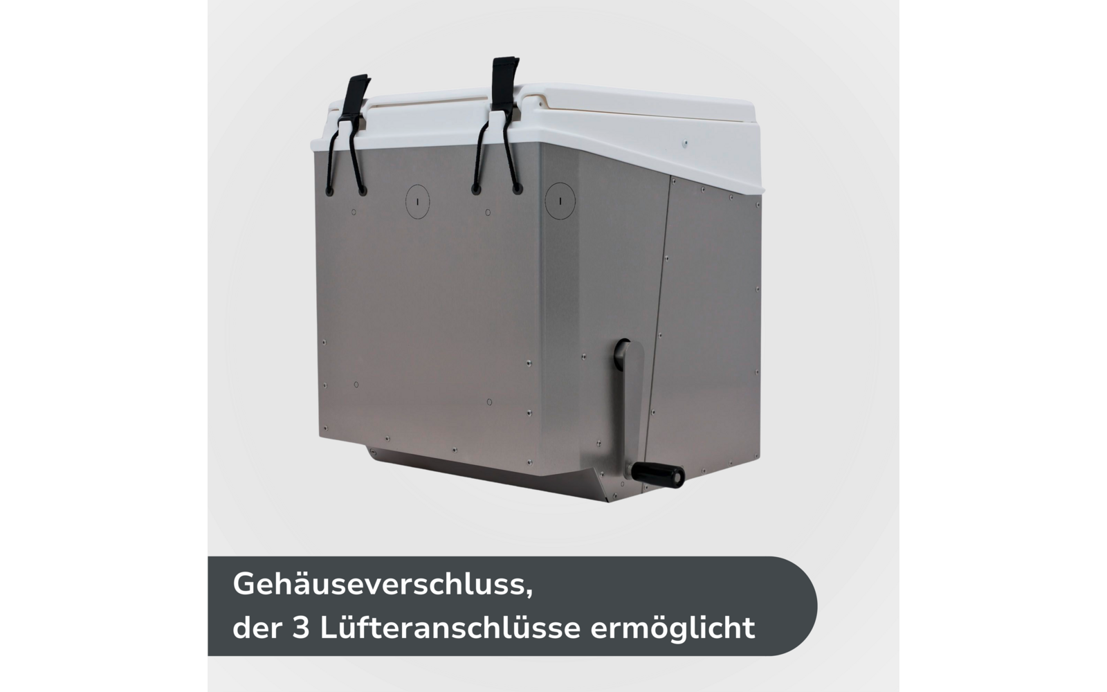 Rechteckiges metallgraues Gehäuse mit weißer Deckelklappe, zwei schwarzen Riemen mit Schnallen an der Vorderkante, drei runden Öffnungen an der Seite und schwarzer Kurbel unten rechts vor hellem Hintergrund