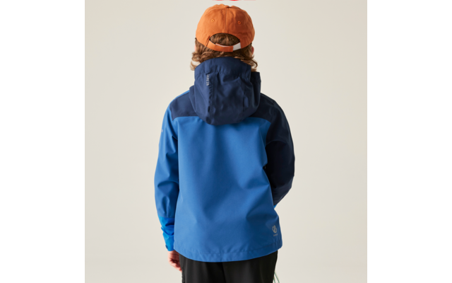Rückansicht einer Person mit orangefarbener Baseballkappe, sichtbaren gewellten Haaren, zweifarbiger blauer Regenjacke und schwarzer Hose