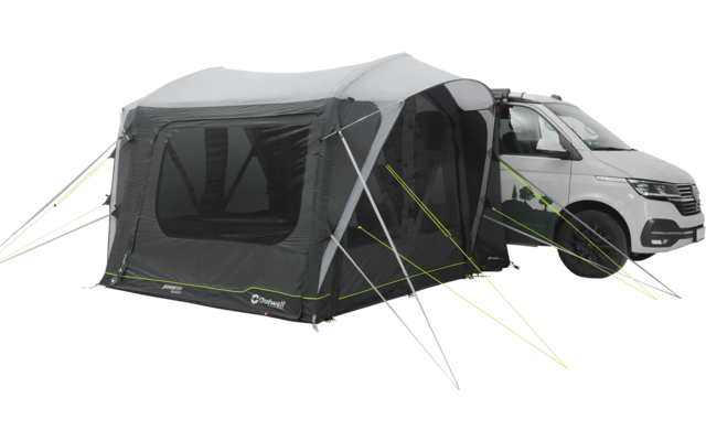 Weißes Wohnmobil mit angehängtem grauen Vorderzelt auf einem gepflasterten Platz