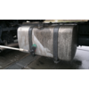 Metalltank unter einem Lkw, eine grüne Bürste an einer Stange berührt den Tank; nasse Streifen, Metallbänder und Fahrgestell sichtbar