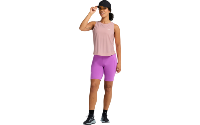 Person steht, trägt schwarze Schirmmütze, rosa ärmelloses Top, violette Radlerhose, schwarze Socken und schwarze Sportschuhe mit hellblauen Details; rechte Hand an Krempe der Mütze