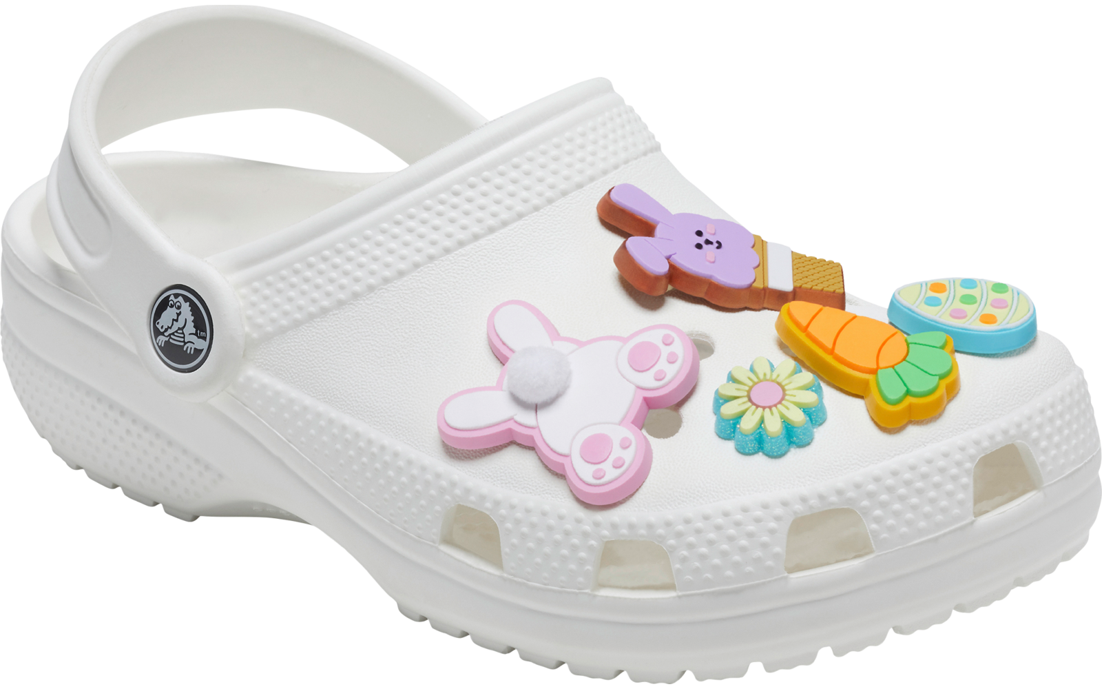Sabot blanc avec trous d'aération et bride arrière, décoré de breloques colorées (lapin rose, carotte orange, deux fleurs, breloque ronde multicolore)