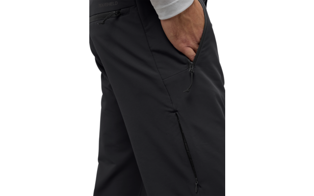 Hand steckt in der linken Hosentasche einer schwarzen Hose