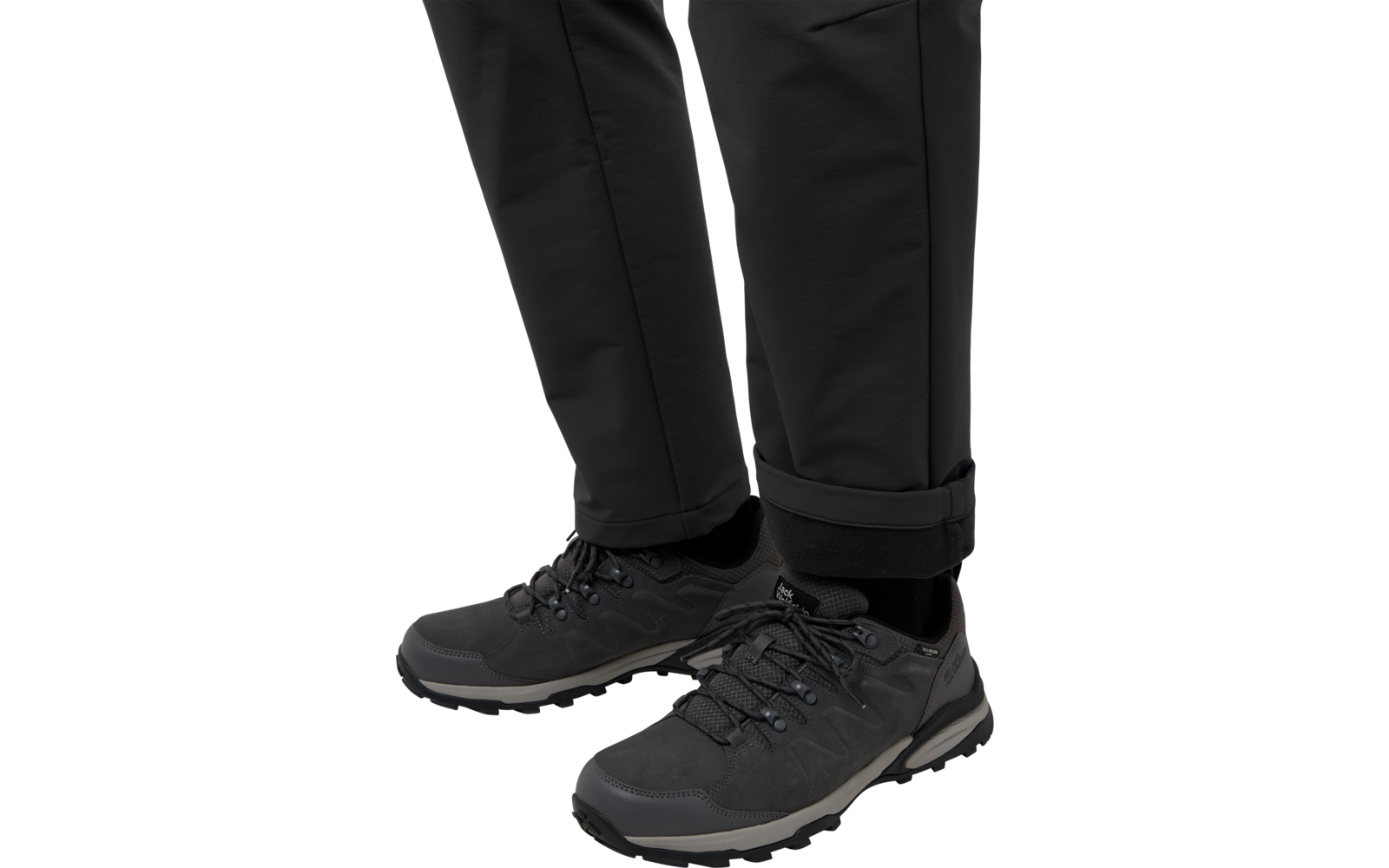 Schwarze Schuhe und schwarze Hose von einer Person, Standaufnahme bis zu den Knöcheln