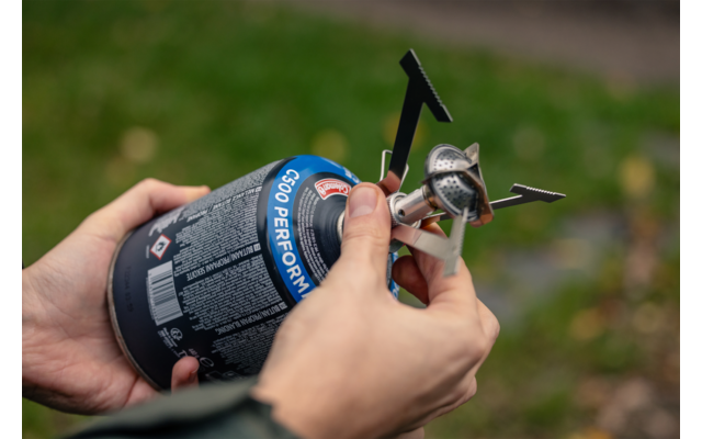 Hand hält ein kleines mechanisches Bauteil mit einer Linse