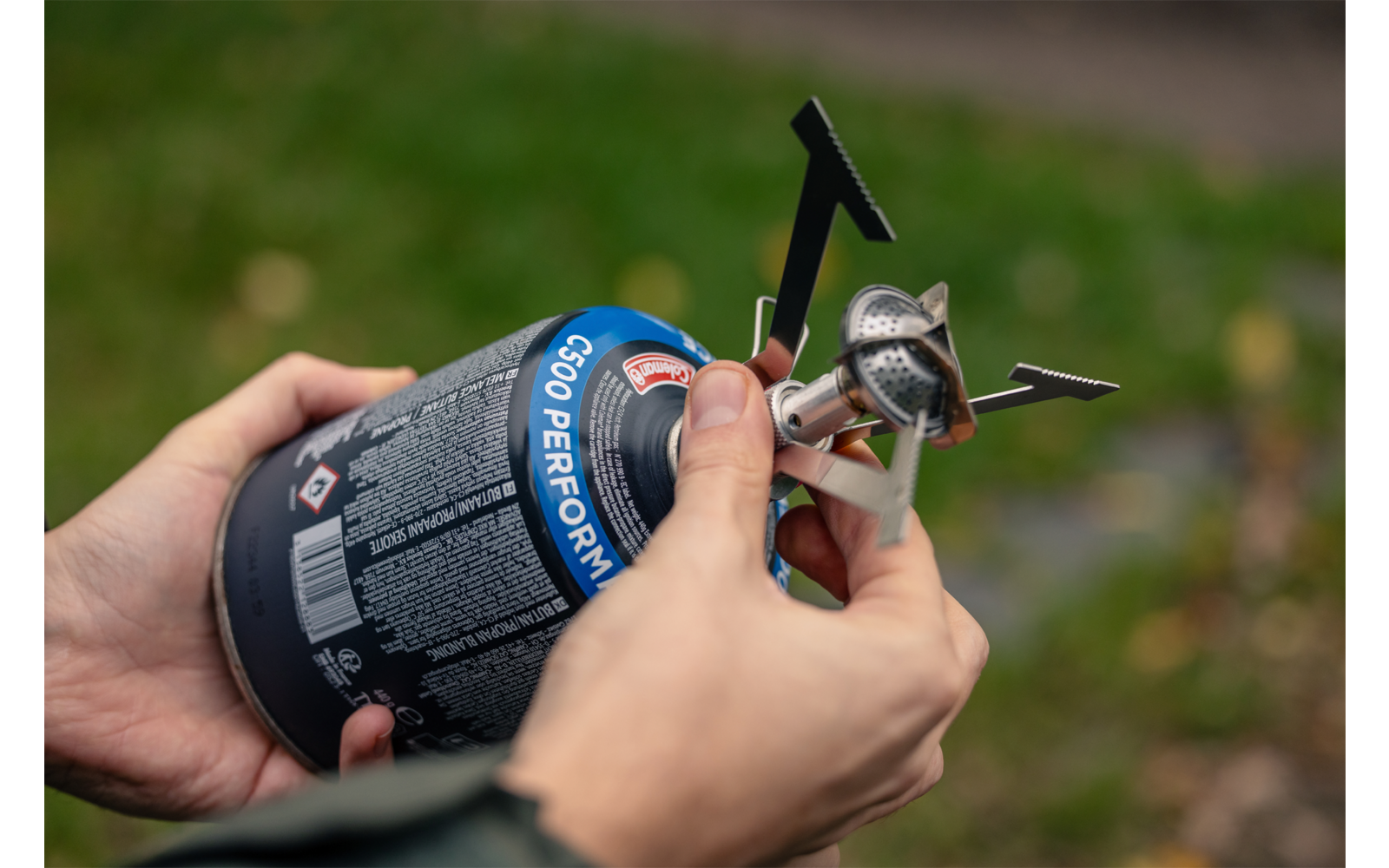 Hand hält ein kleines mechanisches Bauteil mit einer Linse