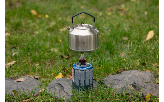Campingkocher mit Topf auf grünem Gras