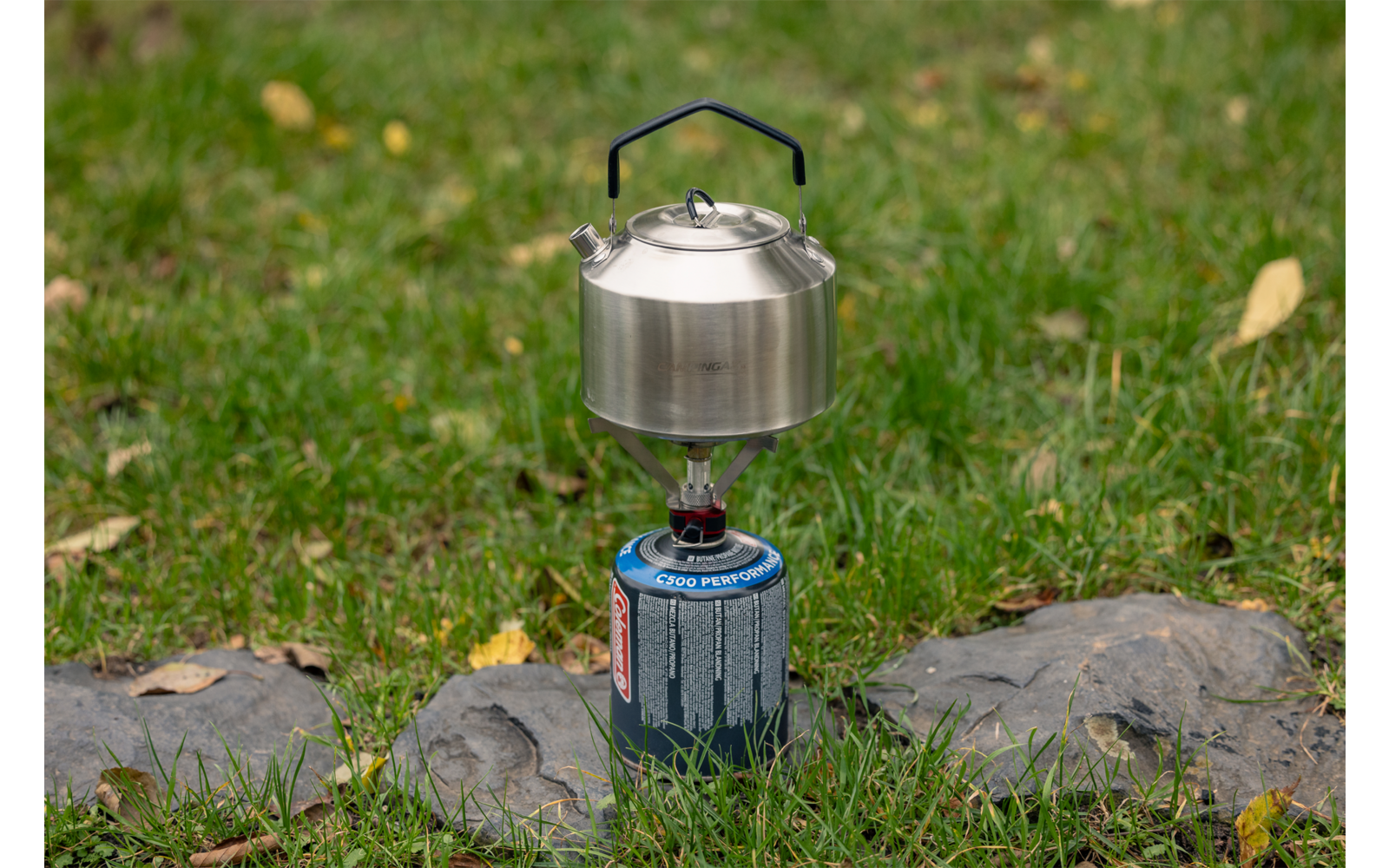 Campingkocher mit Topf auf grünem Gras