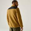 Rückansicht eines Mannes in senfgelber Fleecejacke mit schwarzem Schulterbereich und olivgrünen Hosen