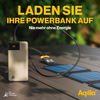 Smartphone wordt opgeladen door een powerbank die op een houten tafel ligt