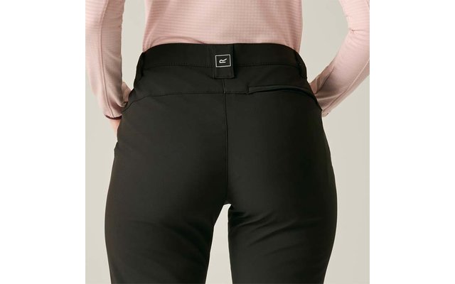 Achteraanzicht van een persoon van taille tot bovenbenen, zwarte broek, lichtroze top met lange mouwen in de taille gestopt, klein vierkant label in het midden van de tailleband, neutrale achtergrond