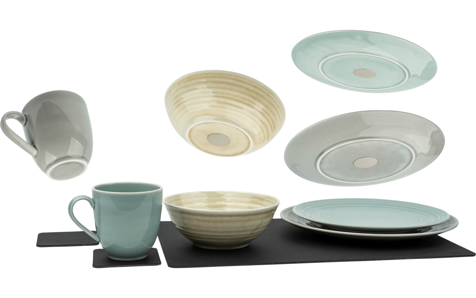 Verschillende kopjes, borden en kommen in pasteltinten, gerangschikt op een witte ondergrond