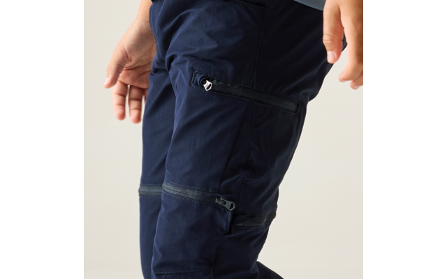 Close-up of navy blue cargo pants with multiple zippers; hands at the edges of the image