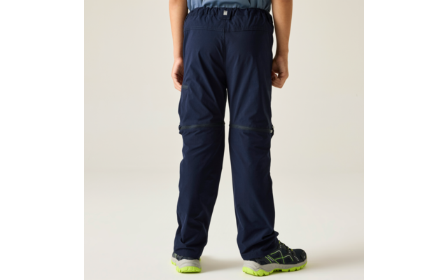 Rear view of a person from the waist down, dark blue pants with zippers at the knees, elastic waistband, right thigh pocket, blue shoes with neon green soles