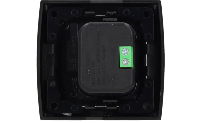 Boîtier carré en plastique noir, composant central rectangulaire arrondi avec texte embossé, à droite petit bornier vert avec deux vis de serrage, quatre orifices de fixation ronds aux coins