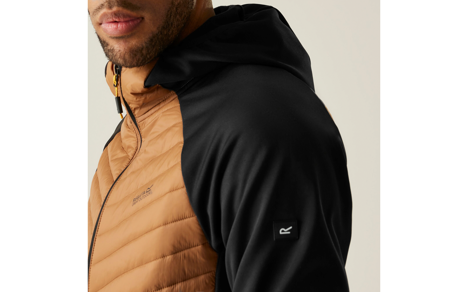 Aufnahme eines Mannes mit einer zweifarbigen Jacke mit Kapuze, braun und schwarz