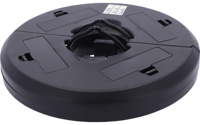 Runde schwarze Kunststoffscheibe mit zentraler runder Öffnung, sichtbarem inneren Zahnkranz, vier rechteckigen Aussparungen und kleinem weißen Etikett oben