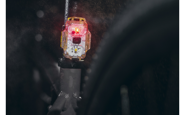 Nahaufnahme eines roten Fahrradrücklichts an einem Fahrrad bei Regen