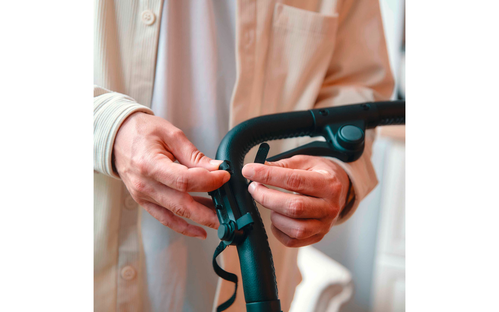 Hände einer älteren Person, die den Griff eines Rollators halten