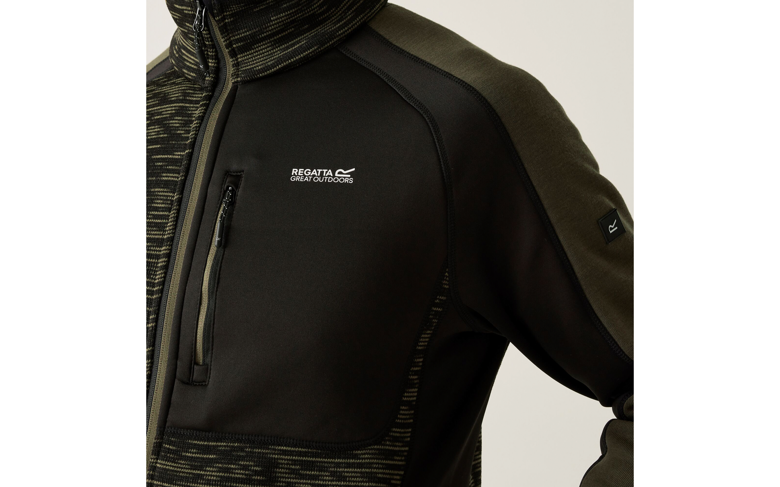 Gros plan d'un buste portant une veste zippée vert olive avec une poche poitrine zippée et le texte blanc «Regatta Great Outdoors» sur la poitrine