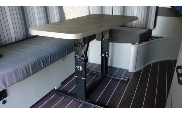 Innenraum eines Fahrzeugs mit einem Tisch, einer Sitzecke und einem Bett