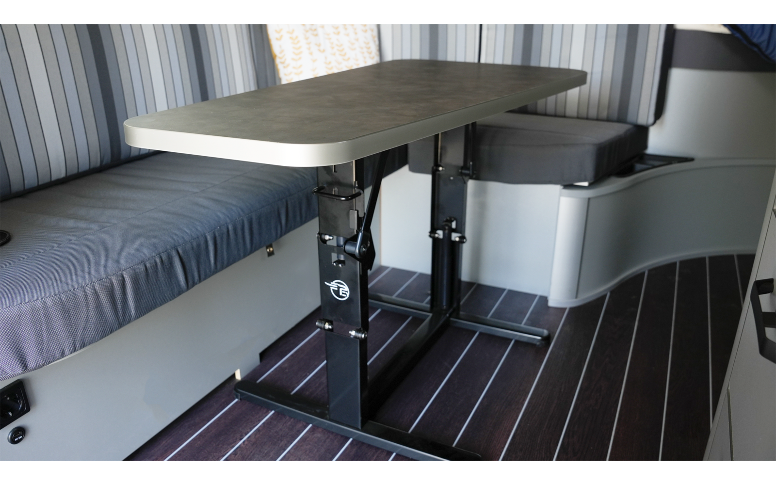 Innenraum eines Fahrzeugs mit einem Tisch, einer Sitzecke und einem Bett